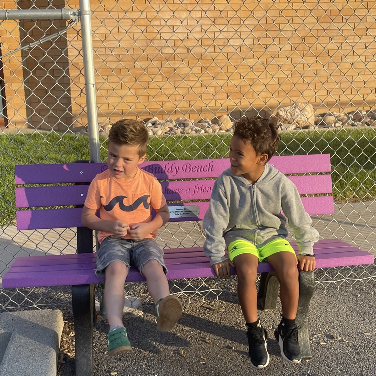 students sitting on a buddy bench at the Highland playground