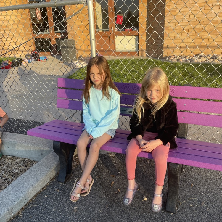 students sitting on a buddy bench at the Highland playground