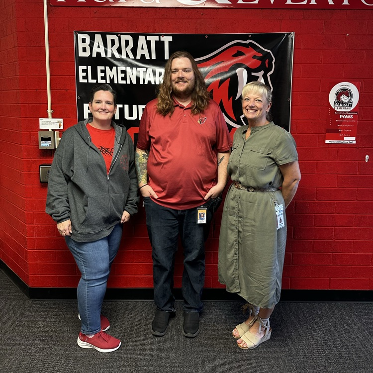 three people standing in front of a red wall