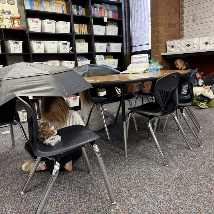 students sitting under desks