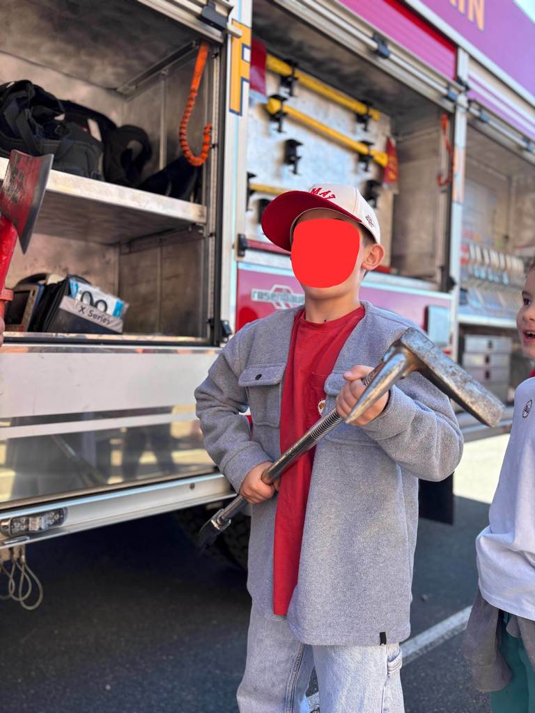 boy holding a fire fighting tool.