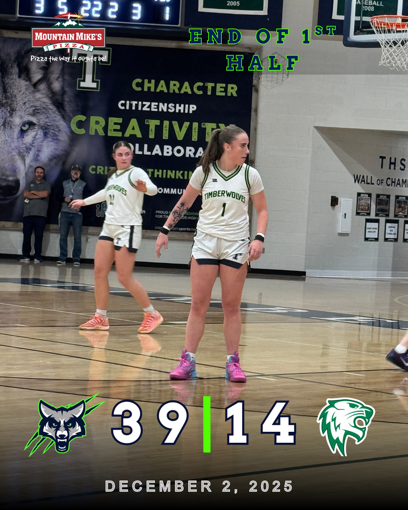 A photo of two Timpanogos High School girls basketball players on the court during a game, wearing white uniforms with green trim. One player stands near mid-court while another gestures behind her. A scoreboard graphic overlay shows “End of 1st Half” and the score Timpanogos 39, South Summit 14, dated December 2, 2025.
