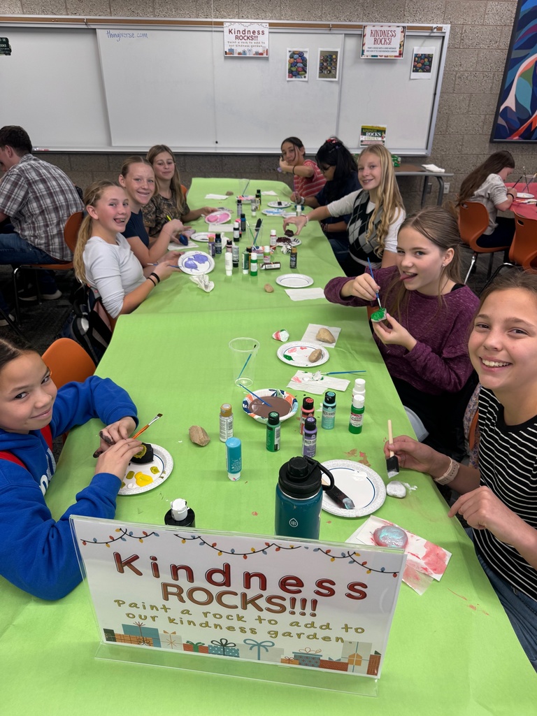 Smiling students painting rocks