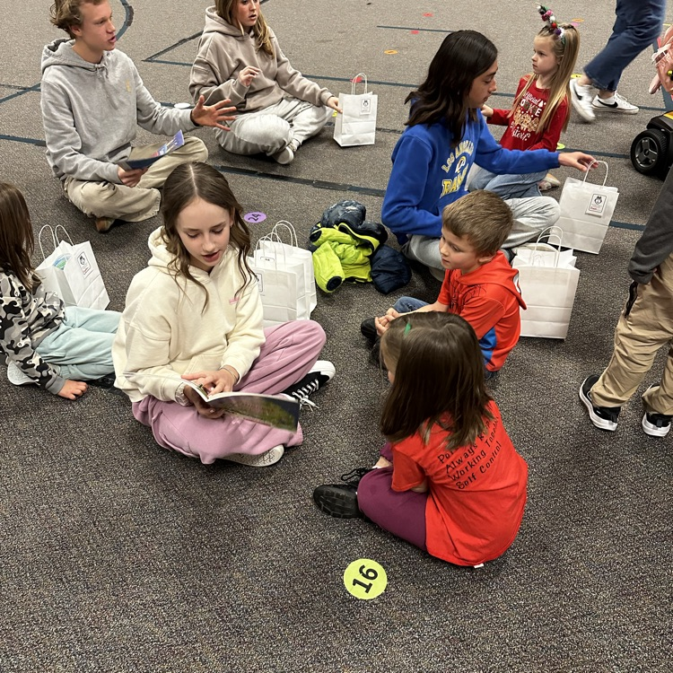 junior high students reading to kindergartners