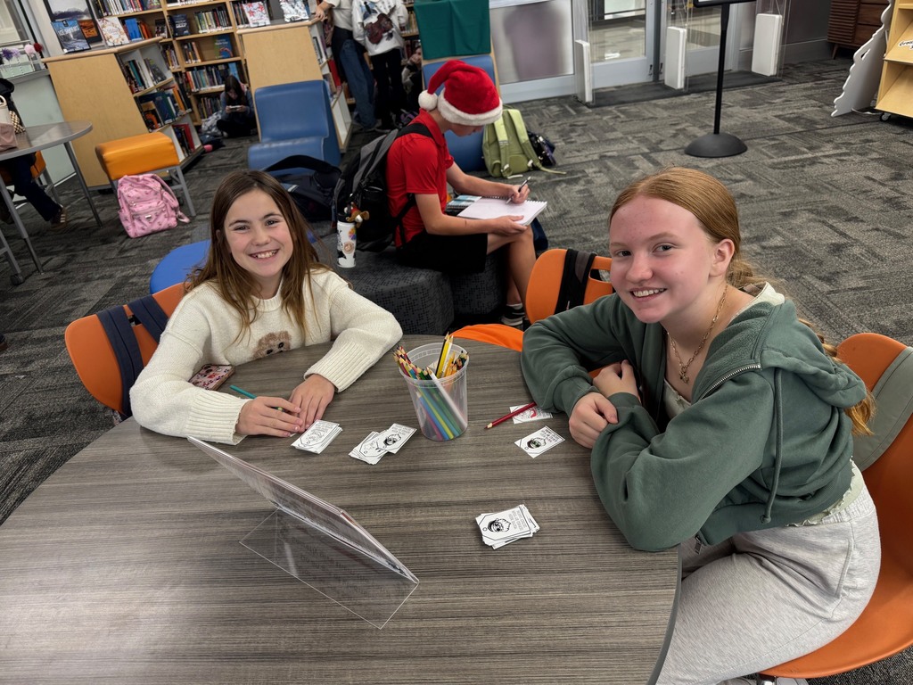 Two girls smiling as they make cards for random acts of kindness.