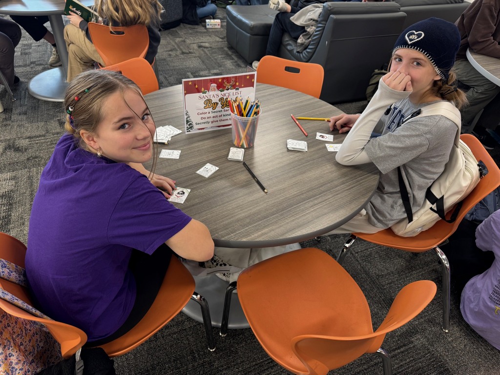 Two girls smiling as they make cards for random acts of kindness.