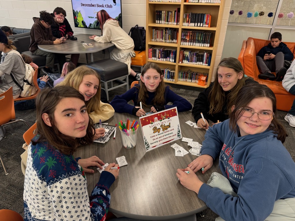 Five girls smiling as they make cards for random acts of kindness.