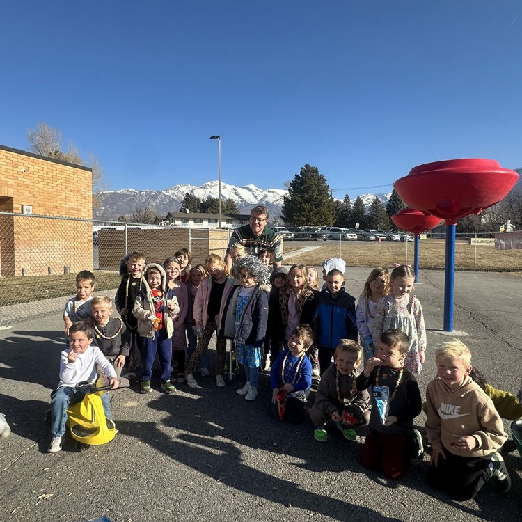 Mr Killpack surround by kindergarteners celebrating 100 days 
