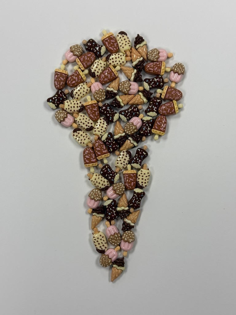 A top-down view of dozens of small, colorful ice-cream-shaped pieces arranged on a plain light background to form the shape of a large question mark.