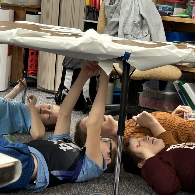 students drawing under the table like Michelangelo