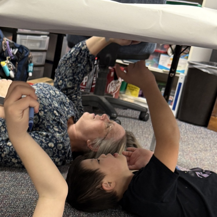 students drawing under the table like Michelangelo