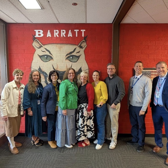 people standing in front of a red wall