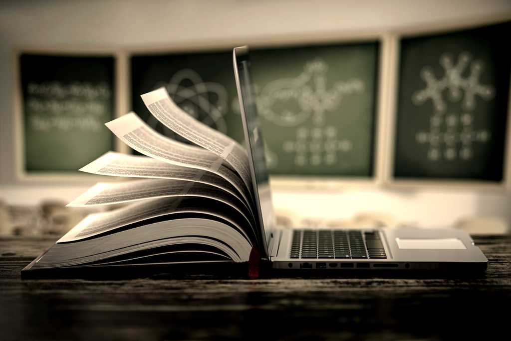 1/2 a book and 1/2 a Chromebook sitting on a desk back to back