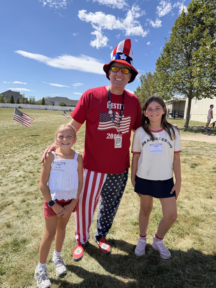 principal and students in red, white, and blue