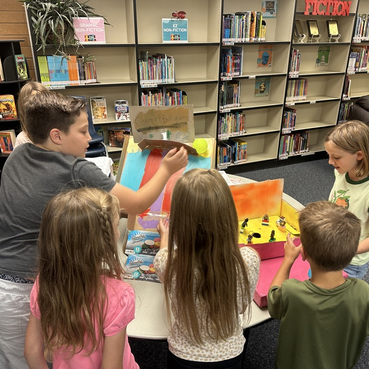 students playing cardboard arcade games.