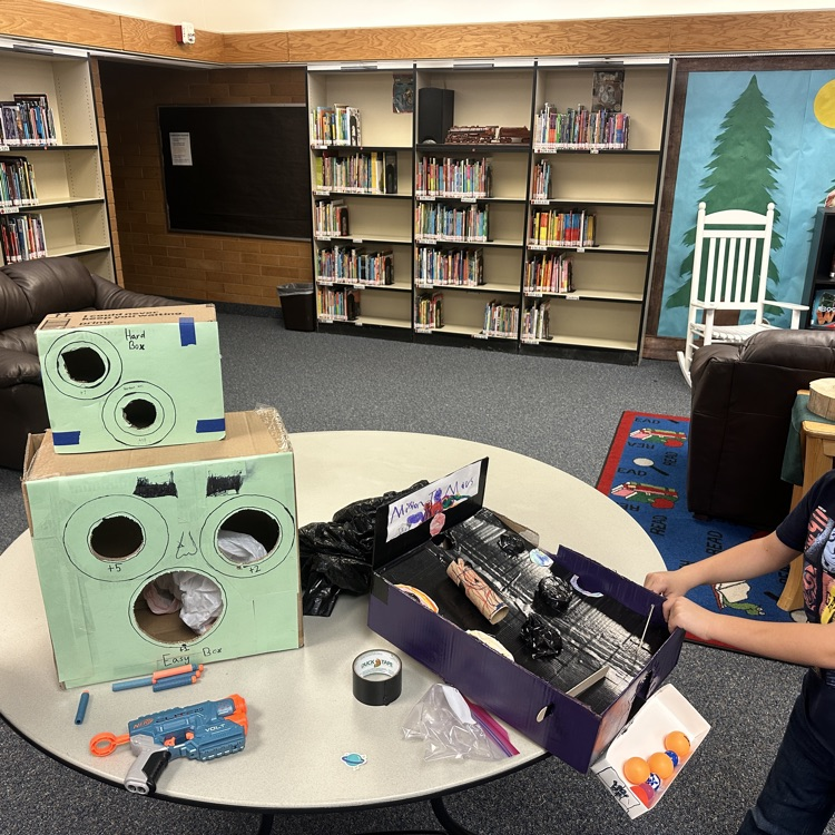 students playing cardboard arcade games.