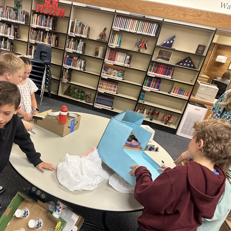 students playing cardboard arcade games.