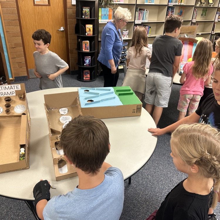 students playing cardboard arcade games.