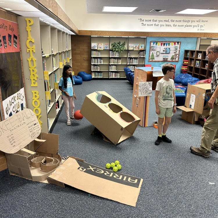 students playing cardboard arcade games.