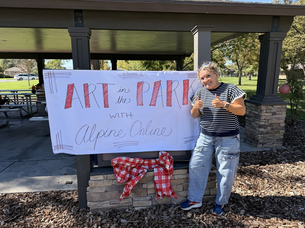 April Felix, school counselor, standing next to sign. 