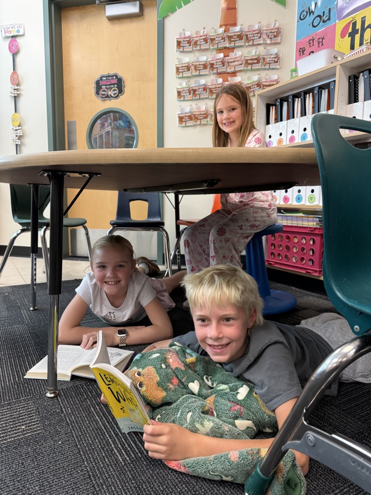 students reading under a classroom table