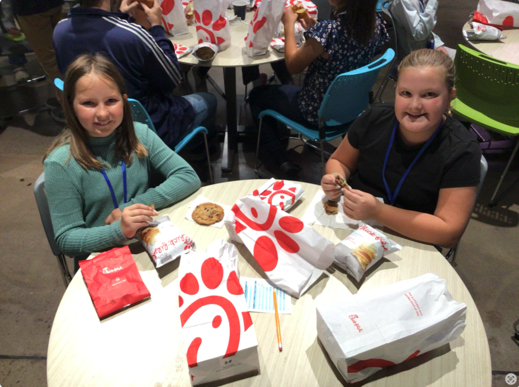 Two students sitting down enjoying lunch.