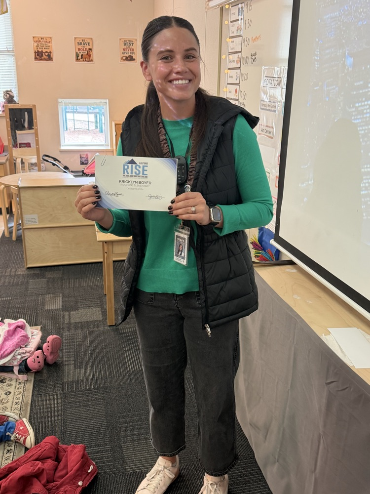 teacher holding a Rise Certificate