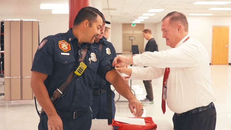 an educators places a tourniquet on a firefighter