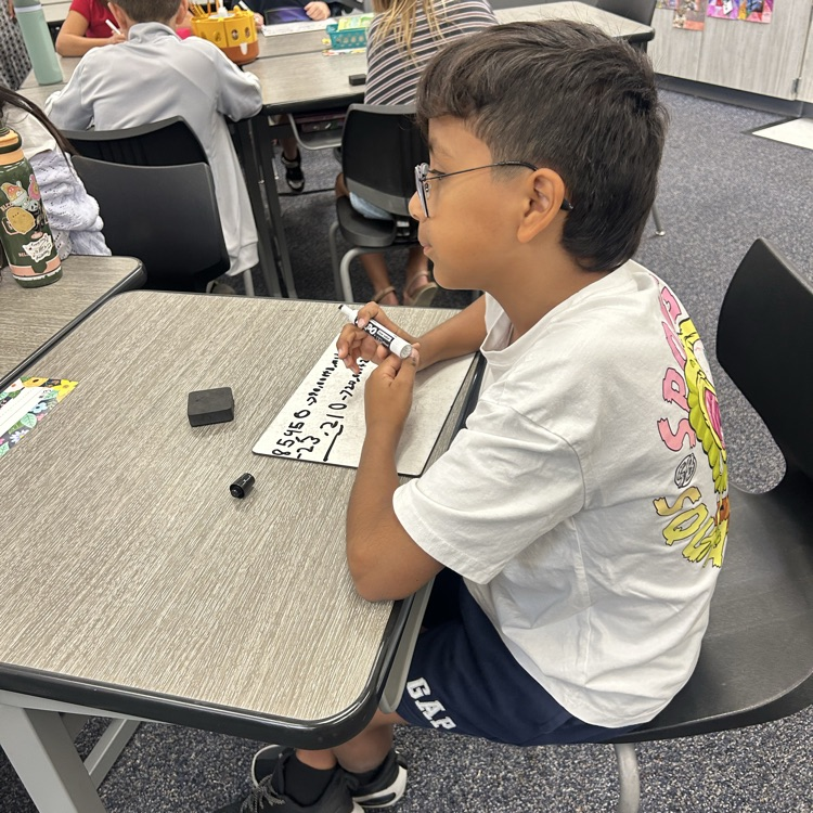 student using a whiteboard to solve a math problem
