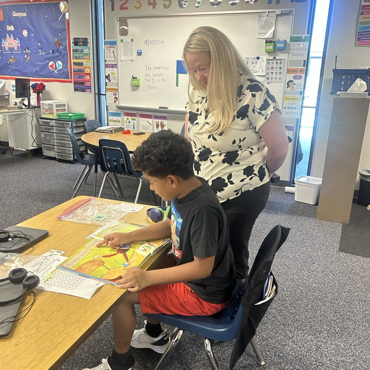 student reading to Principal Peralta 