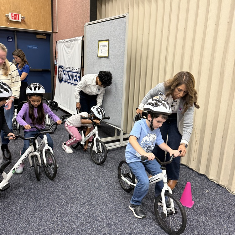 Council women's Scott helping kindergartners onto the bike