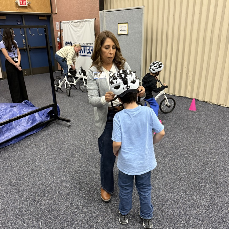 Kristine Scott helping students with bike helmets