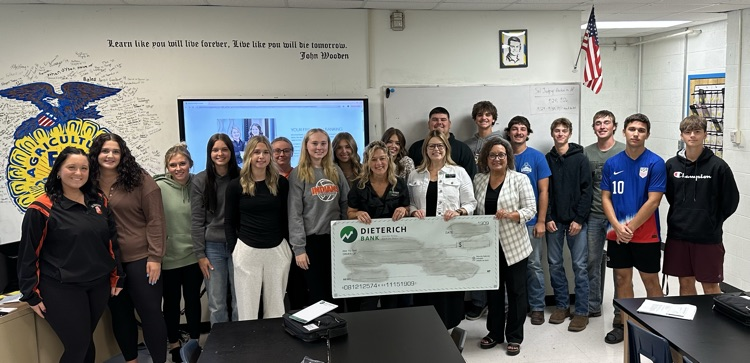 Students and presenters lined up with big check 