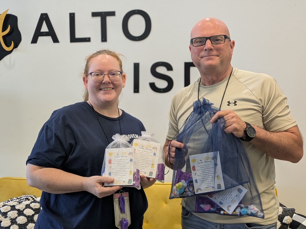 Teacher and Superintendent holding "blessing bags"