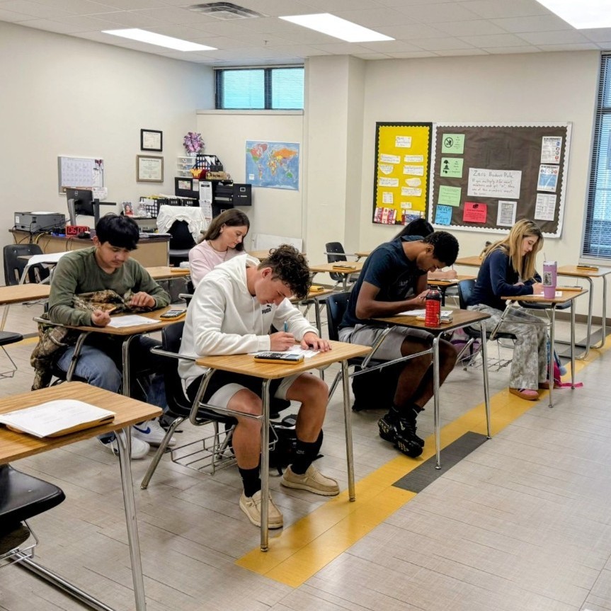 students seated at desks writing