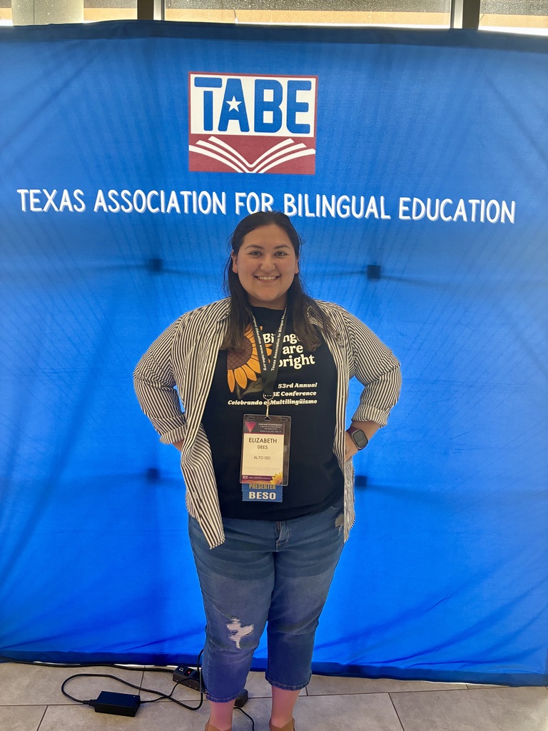 Mrs. Dees in front of a TABE banner.