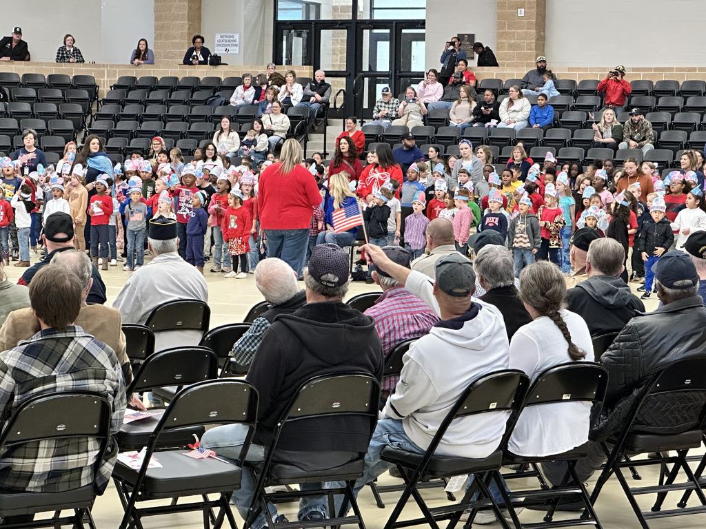 veterans watching elementary students singing