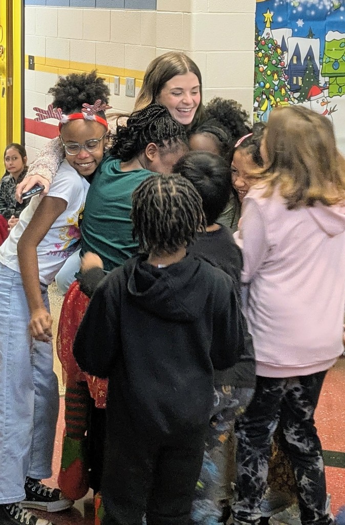 Ms. Sarandos hugging students