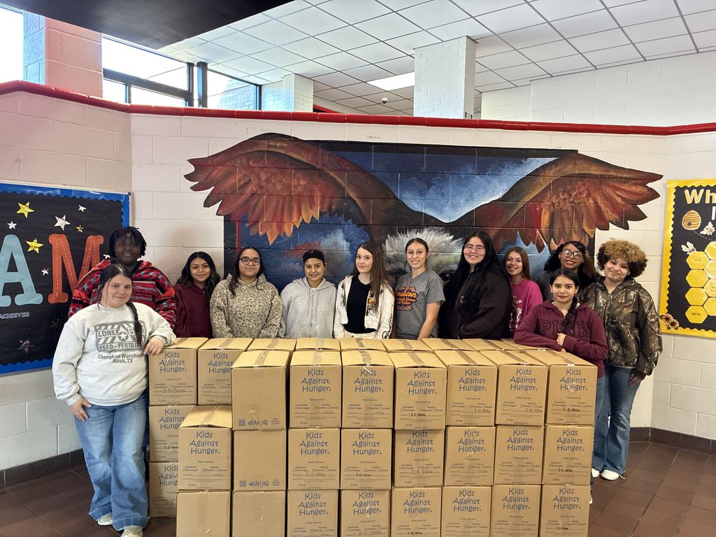 students posing with boxes of meals