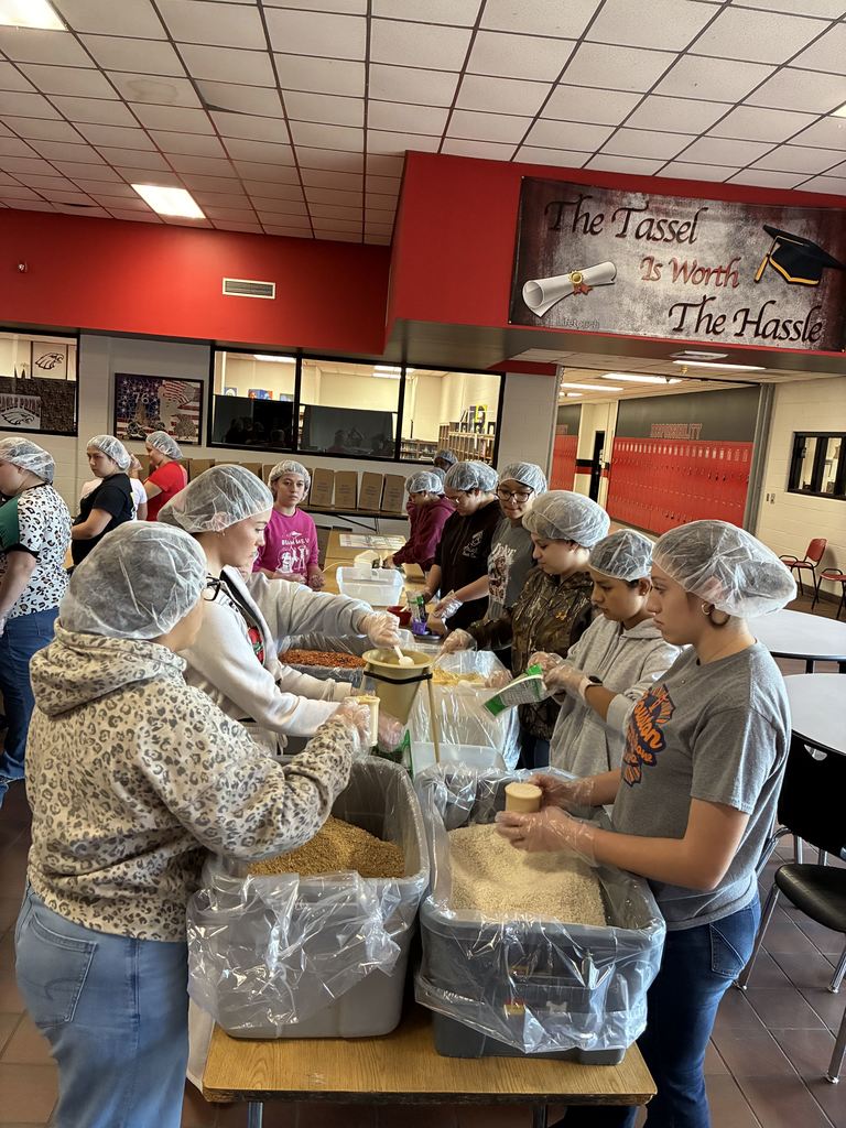 students wearing hairnets packaging meals