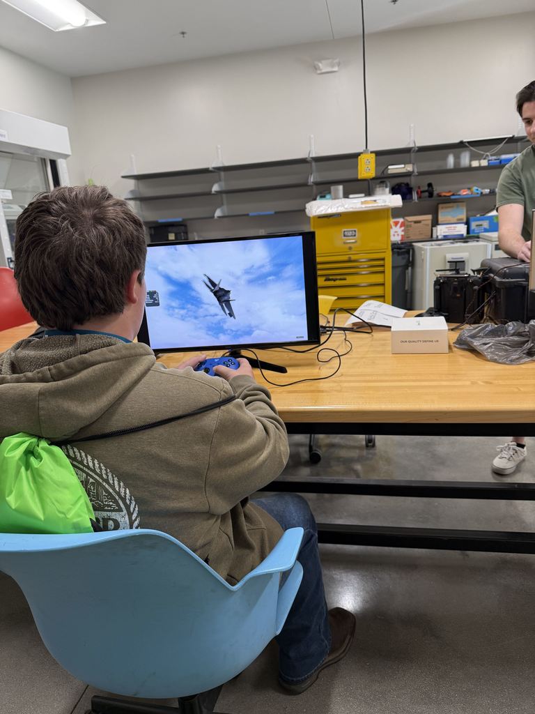 Macoy Reeves testing out a flight simulator with the Miner Aviation Team in the Student Design Center.