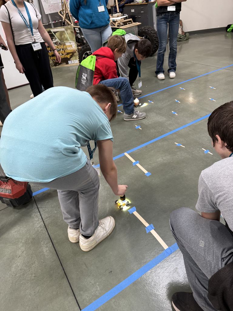Riley Hollis, Owen Combs, and Brentley Pope testing out solar-powered cars with the Baja SAE team in the Student Design Center.