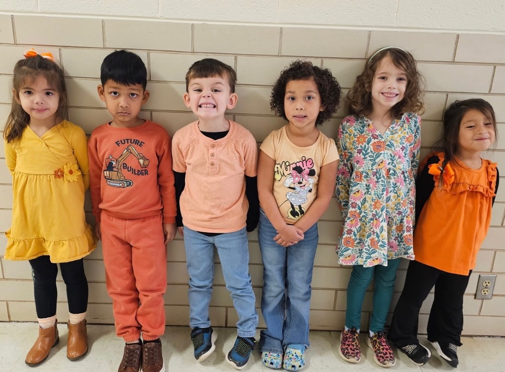 students smiling and wearing orange