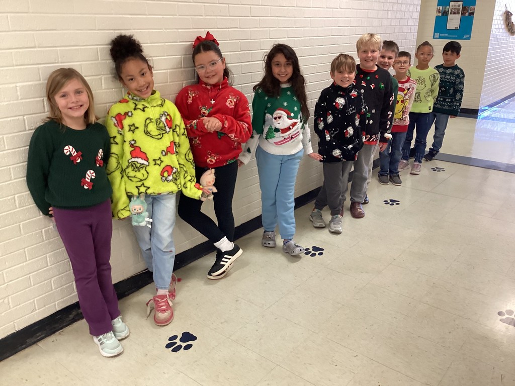 Students wearing Christmas sweaters.