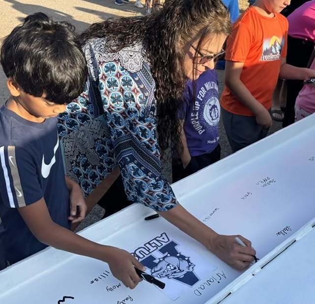 Mrs. Cook signs the beam.