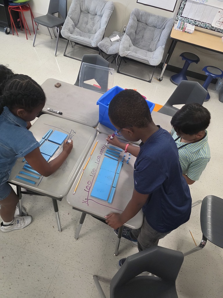 Students solving area model with base ten blocks