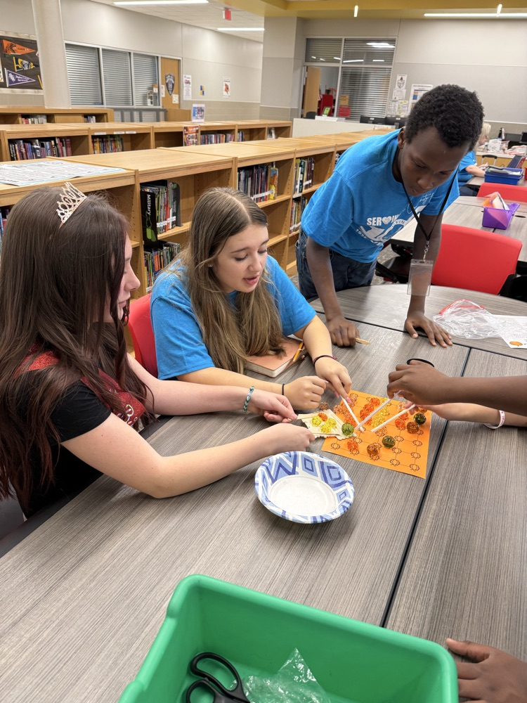 Students working to “harvest pumpkins” with limited resources