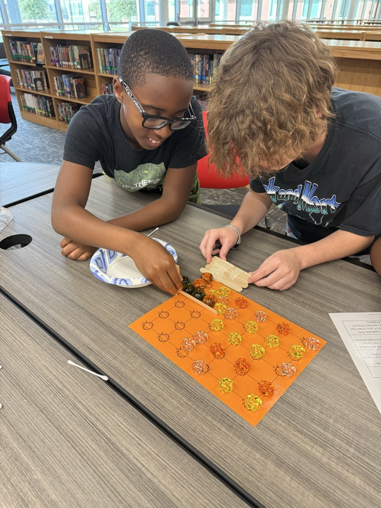 Students working to “harvest pumpkins” with limited resources