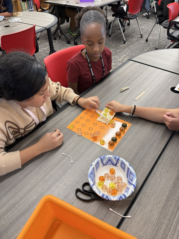 Students working to “harvest pumpkins” with limited resources