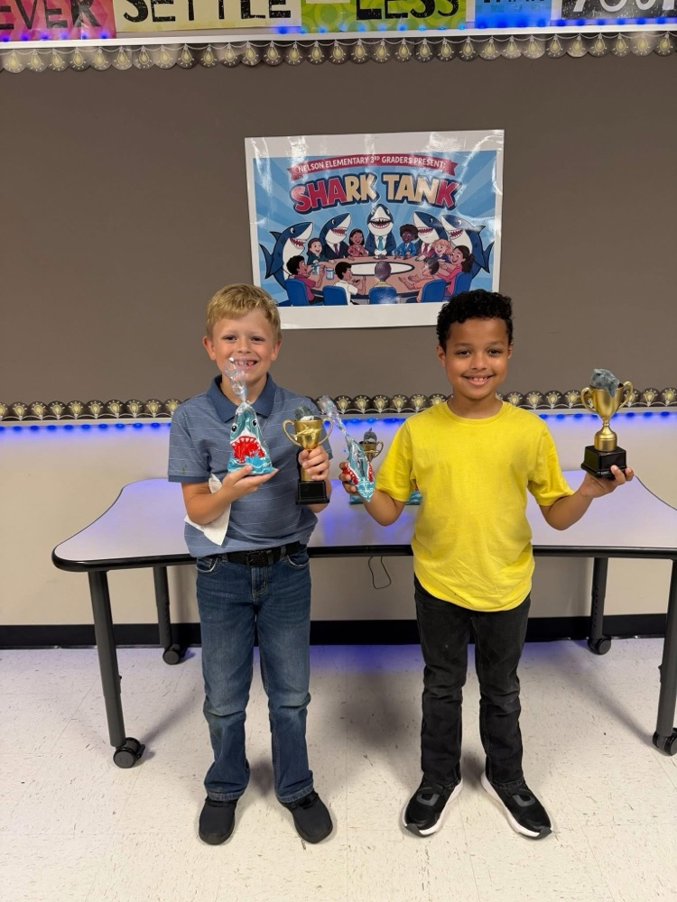 Students who participated in Shark Tank with trophies